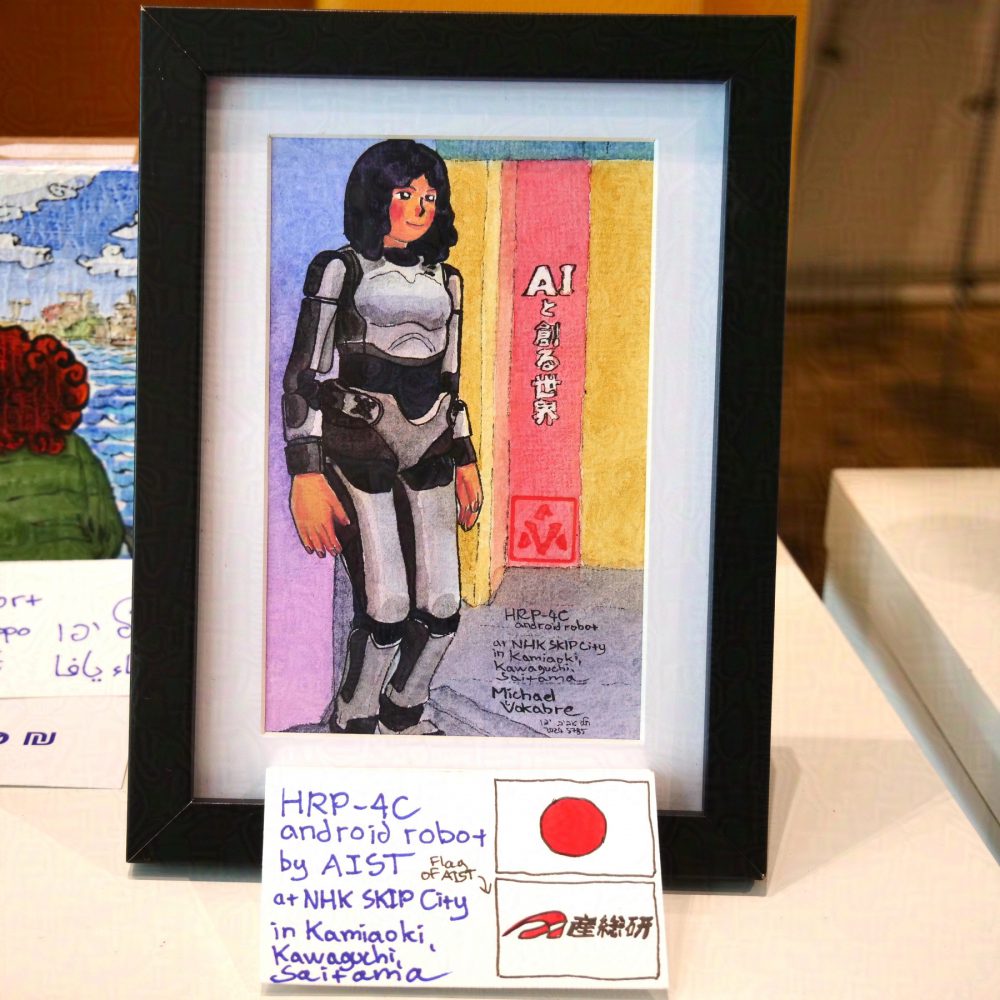The painting described before is photographed in a frame, the frame is black, and between the frame and the painting is white background. Below is a plaque, hand written, in English, with the flag of Japan and flag of AIST on the right.