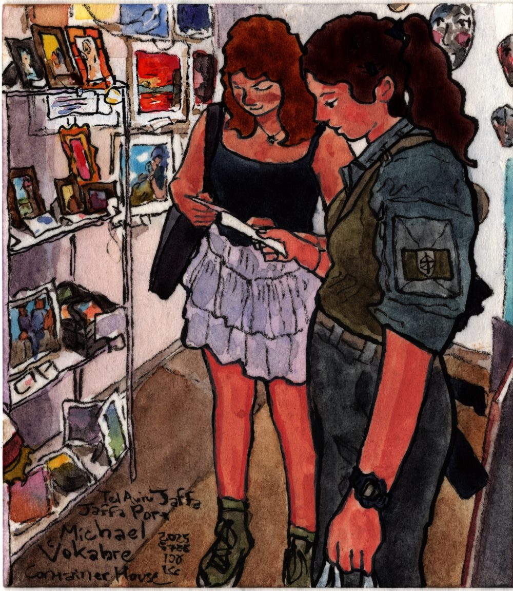 A painting in watercolour with ink lines, square-ish vertical. In the middle are two women, holding postcards and looking at them. The woman on the right, in the front, wears military uniform, has a gun on her back, holds the postcard in her left hand, and a plastic bag in her left hand. She has dark brown hair. The woman in the back wears a skirt, a top, and has orange-ish hair. On the left is a stall with different artworks in frames, behind are more artworks in frames. On the right are ceramic on the wall. The painting is signed Tel Aviv Jaffa, Jaffa Port, Michael Vokabre, Container House 2025 5786 Acre.